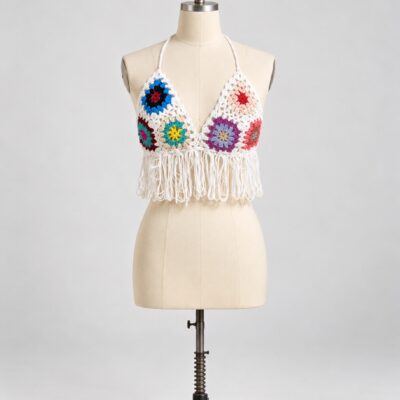 Front view of an ivory crochet halter top with multicolor granny motifs, a deep V neckline and long looped fringe