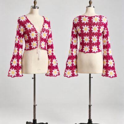 Front and back of a raspberry crochet cardigan with white daisy motifs, yellow centers, front ties and bell sleeves