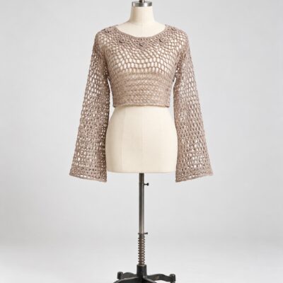 Front view of a taupe openwork crochet crop top with a rounded neckline, floral yoke detail and long flared sleeves